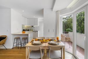 uma cozinha e sala de jantar com mesa e cadeiras em WHome Chic & Stylish Retreat in Estoril's Finest Location em Estoril