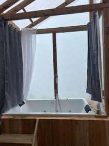 a bath tub sitting in front of a window at Cloudwalk Treehouse in Jibhi