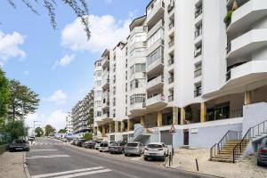 um edifício de apartamentos numa rua com carros estacionados em WHome Chic & Stylish Retreat in Estoril's Finest Location em Estoril