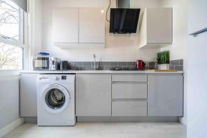 a kitchen with a washing machine and a sink at Modern flat in Moseley with Free Parking in Birmingham