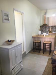 a kitchen with white cabinets and a counter top at La Maison Du Village in Lartos