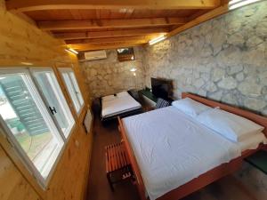 a bedroom with a large bed and a stone wall at relax in Marusici 