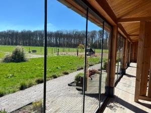 une terrasse couverte avec vue sur un champ dans l'établissement 't Heidepaleis, à Garderen