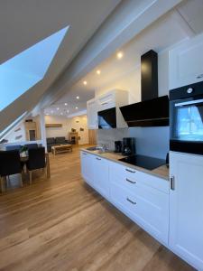 a kitchen with white cabinets and a dining room at Ferienhaus Freimuth in Mesenich