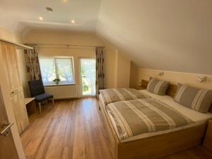 a bedroom with a large bed and a chair at Ferienhaus Freimuth in Mesenich