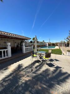 een patio met een tafel en stoelen en een zwembad bij Casa Rural El Limonero in Villanueva de la Serena
