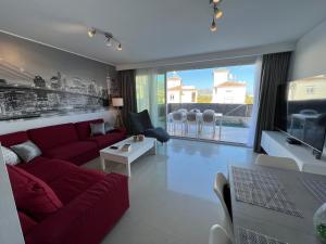 sala de estar con sofá rojo y ventana grande en Villa Antonia Mar - Private Pool - Punta Lara Nerja en Nerja
