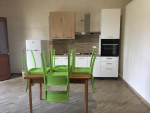 una cucina con sedie verdi e tavolo in legno di Residence Le Tamerici a Cariati