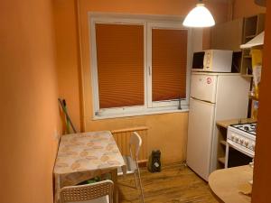 eine kleine Küche mit einem Tisch und einem weißen Kühlschrank in der Unterkunft Minties Street big 47 square meters apartment for 1-5 persons in Vilnius