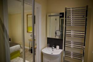 a bathroom with a sink and a mirror at Tu Guesthouse in Stanley