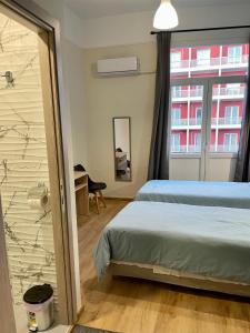 a bedroom with a bed and a window and a desk at Hotel Kastoria in Thessaloniki
