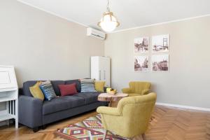 uma sala de estar com um sofá e duas cadeiras em Central Park Apartments em Belgrado