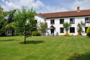 una gran casa blanca con un patio verde en Burnt House Farm en Highbridge