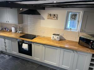 a kitchen with a wooden counter top with a microwave at Quirky Cottage in the Heart of Appleby in Appleby