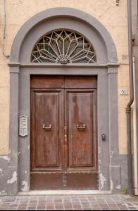 a large wooden door with an arch above it at CASA BENVENUTI in Pisa