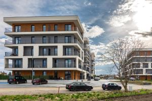 a tall building with cars parked in front of it at ENERGYLANDIA Zator Apartament Asia in Zator