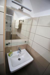 bagno con lavandino bianco e specchio di VÁRLAK VENDÉGHÁZ Apartman 2 a Siófok