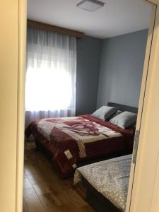 um quarto com uma cama e uma janela em Vila ISKRA em Novi Sad
