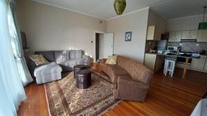 ein Wohnzimmer mit 2 Sofas und einer Küche in der Unterkunft Huisie Langs Die See in Swakopmund