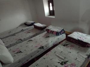 3 camas individuales en una habitación con espejo en Gîte Assafar, en Kalaat MGouna