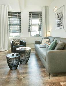 a living room with a couch and two chairs at Historischer Ohlerich Speicher Hafen Wismar Ap.18 in Wismar