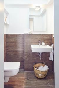 ein Bad mit einem Waschbecken, einem WC und einem Korb in der Unterkunft Historischer Ohlerich Speicher Hafen Wismar Ap.18 in Wismar