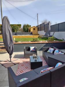 - une terrasse avec 2 canapés et un parasol dans l'établissement La ferme de Pham, à Belberaud