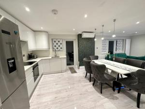 uma cozinha e sala de jantar com mesa e cadeiras em Luxury House em Greenford