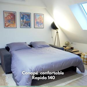 una camera da letto con un grande letto con lenzuola blu di Tout simplement: confort ! a Bourges