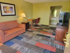 a living room with a couch and a desk and a television at Studio 9 Inn & Suites in Decatur