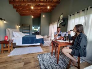 two women are sitting at a table in a bedroom at Chalé Morro Grande in Paraisópolis