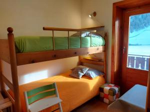 um quarto com 2 beliches e uma cadeira em BAITA SOLDANELLA - Livigno em Livigno