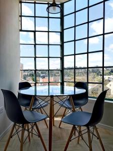 a glass table and chairs in front of a large window at The Beauty Queen of Jerusalem in Jerusalem