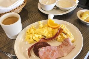 a plate of breakfast food with bacon and eggs at Jardim das Acácias in Maputo