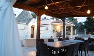 a wooden table and chairs on a patio at Trulli Magnolia in Putignano