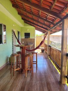 a porch with a bar and stools on a deck at Chalé Terê na Serra da Canastra in São Roque de Minas