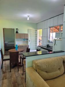 uma cozinha e sala de estar com um sofá e uma mesa em Chalé Terê na Serra da Canastra em São Roque de Minas