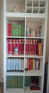 een boekenplank gevuld met veel boeken bij Peppe's house in Gravina di Catania
