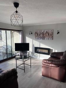 een woonkamer met een bank, een tv en een tafel bij Bellman 12, Newly Refurbished 2023, Lake View, Pet Friendly in Bowness-on-Windermere