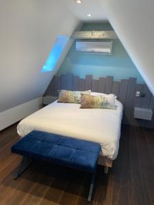 a bedroom with a bed with a blue wall at La Mezzanine des Rohan Saverne in Saverne