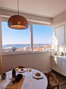 a table with two plates of food and a large window at ARENA Sunset, Sea Coloseum View, 2 Rooms free Parking in Pula