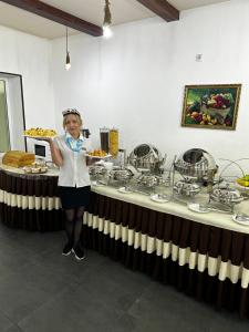 a woman standing in front of a table with food at Temurkhan Hotel in Tashkent +19 photos