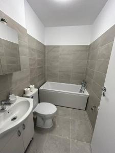 ChiajnaApartament cu loc de parcare的浴室配有卫生间、浴缸和水槽。