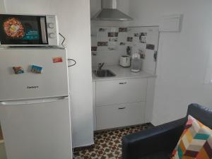 a small kitchen with a refrigerator and a microwave at Estudio Alicia in Rota