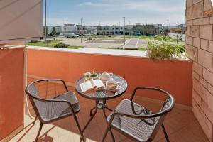 una mesa y sillas en un balcón con vistas en Appartamento Dada, en Carmiano