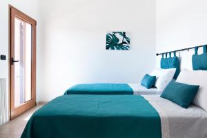 1 dormitorio con 2 camas en azul y blanco en Appartamento Dada, en Carmiano