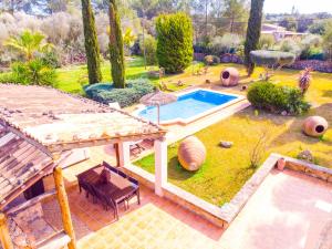 un patio trasero con piscina, mesa y sillas en Incredible villa with wonderful exteriors, en Sencelles