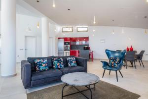 een woonkamer met een bank en stoelen en een keuken bij Villa Selene heated Indoor Pool in Costa Calma