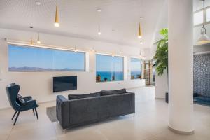 een woonkamer met een bank en een groot raam bij Villa Selene heated Indoor Pool in Costa Calma