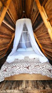 a bed in a wooden cabin with a mosquito net at Mana Star Lounge Hotel in Villavieja